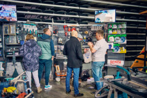 Zwiedzający oglądają narzędzia elektryczne na stoisku targowym
