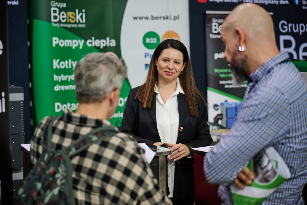 Doradca rozmawia ze zwiedzającymi o pompach ciepła i kotłach